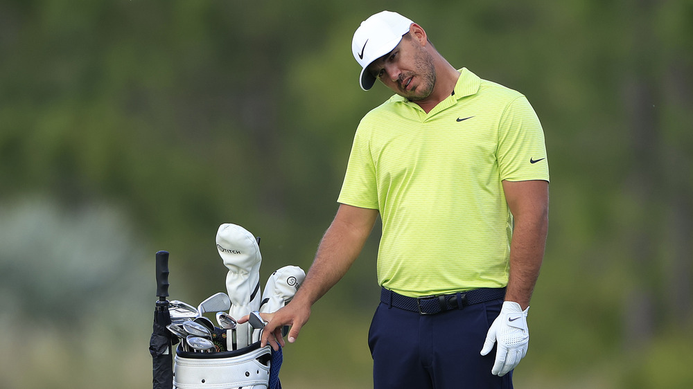 Brooks Koepka rolls his neck on the green in 2021