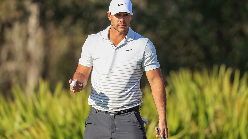 Brooks Koepka walking with golf ball in hand