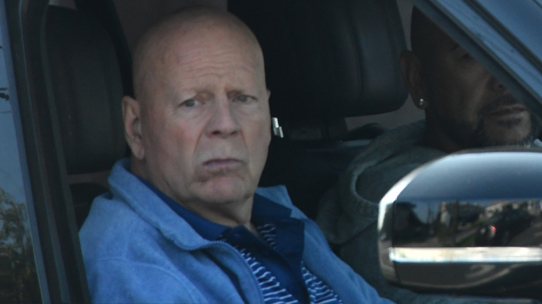 Bruce Willis sitting in the passenger seat of a car