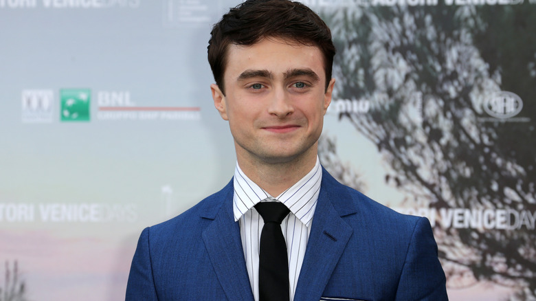 Daniel Radcliffe in a suit smiling for a picture