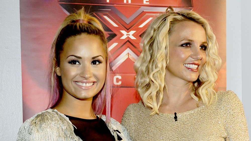 Demi Lovato and Britney Spears both posing and smiling