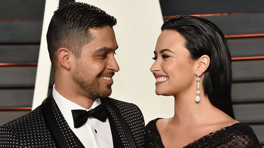 Wilmer Valderrama and Demi Lovato smiling at one another