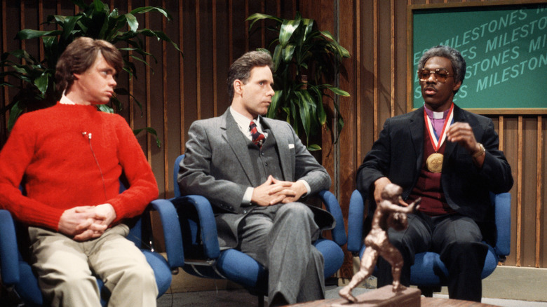 Eddie Murphy during a Saturday Night Live sketch wearing sunglasses, a blazer and a gold medal