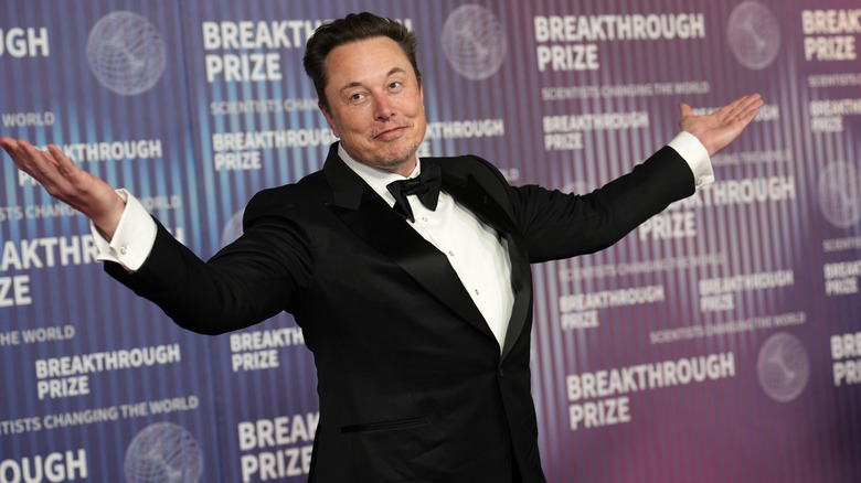 Elon Musk gesturing with his hands up