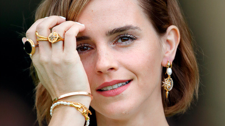 Emma Watson with her hand to her face