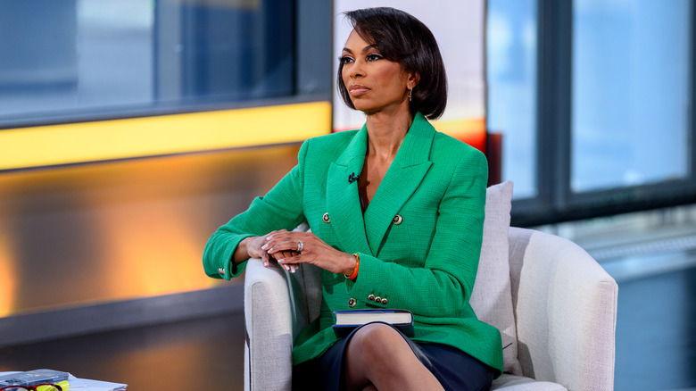 Harris Faulkner sitting in a char wearing a vibrant green jacket