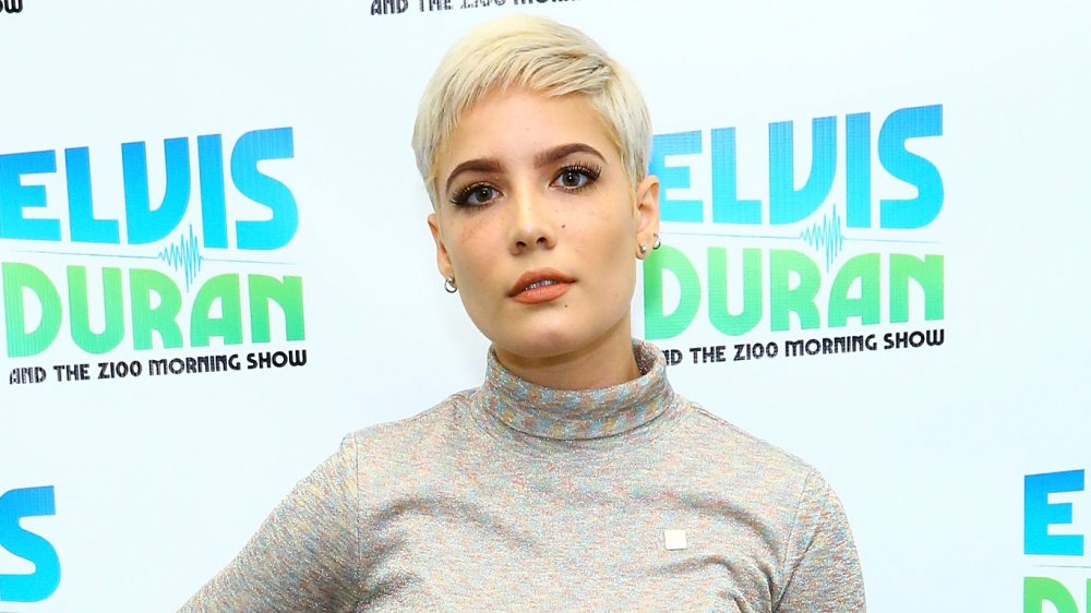 Halsey with short blonde hair and grey mock-neck top