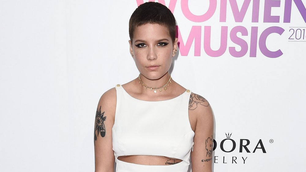 Halsey with dark short hair and tattoos on arms