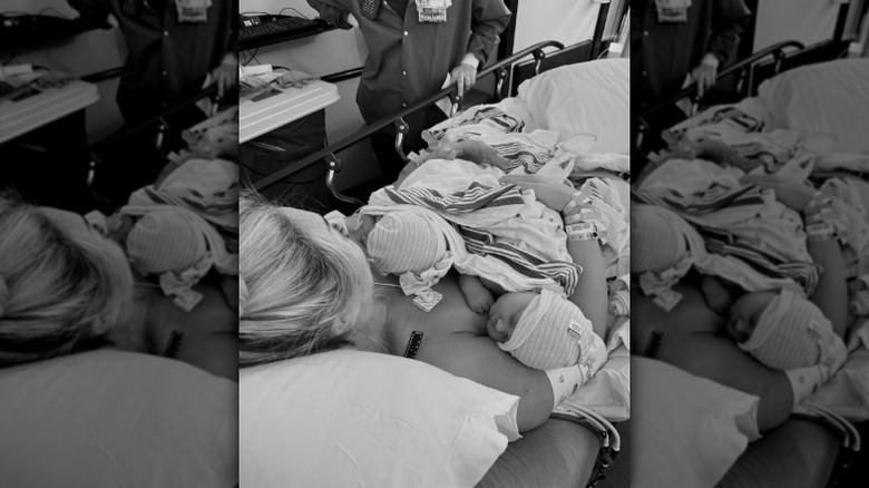 Brooke Hogan lies in a hospital bed holding her twins