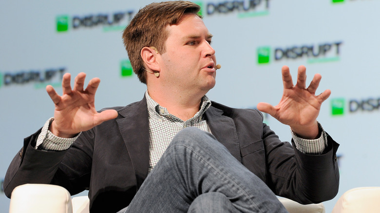 JD Vance sitting down with his hands up