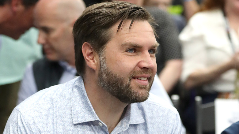 JD Vance smiling at a Nascar event in a white shirt