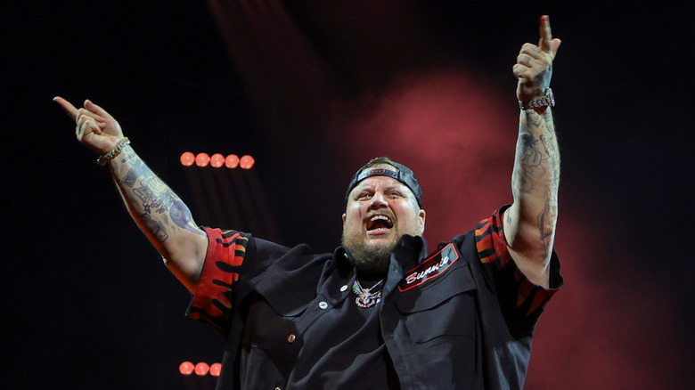 Jelly Roll on stage with his hands up