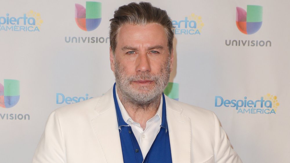 John Travolta in a white suit, with beard