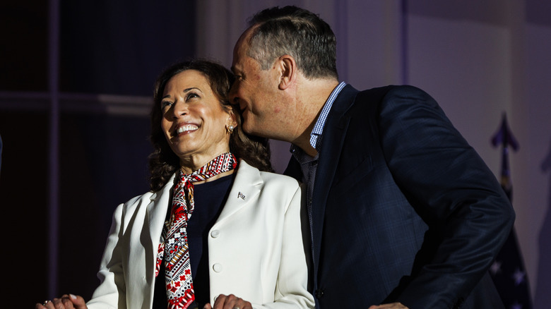 Second Gentleman Doug Emhoff whispering to Vice President Kamala Harris as they watch the fireworks over the National Mall from the White House balcony