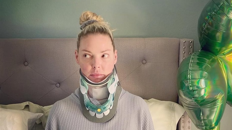 Katherine Heigl wearing a neck brace while sitting in.a hospital bed