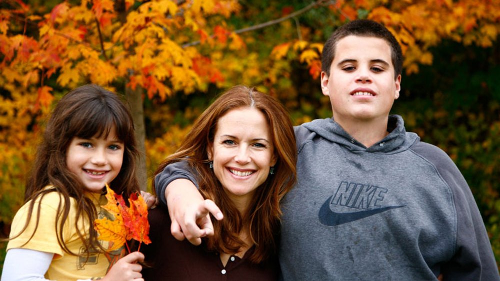 Ela Travolta, Kelly Preston, and Jett Travolta hugging in a family photo