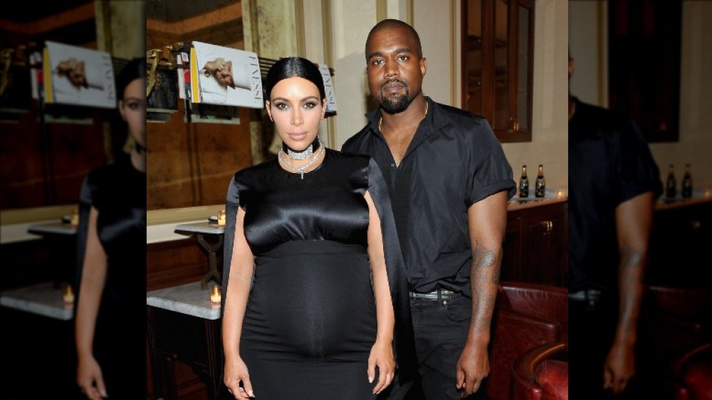 Kim Kardashian looking visibly pregnant and Kanye West