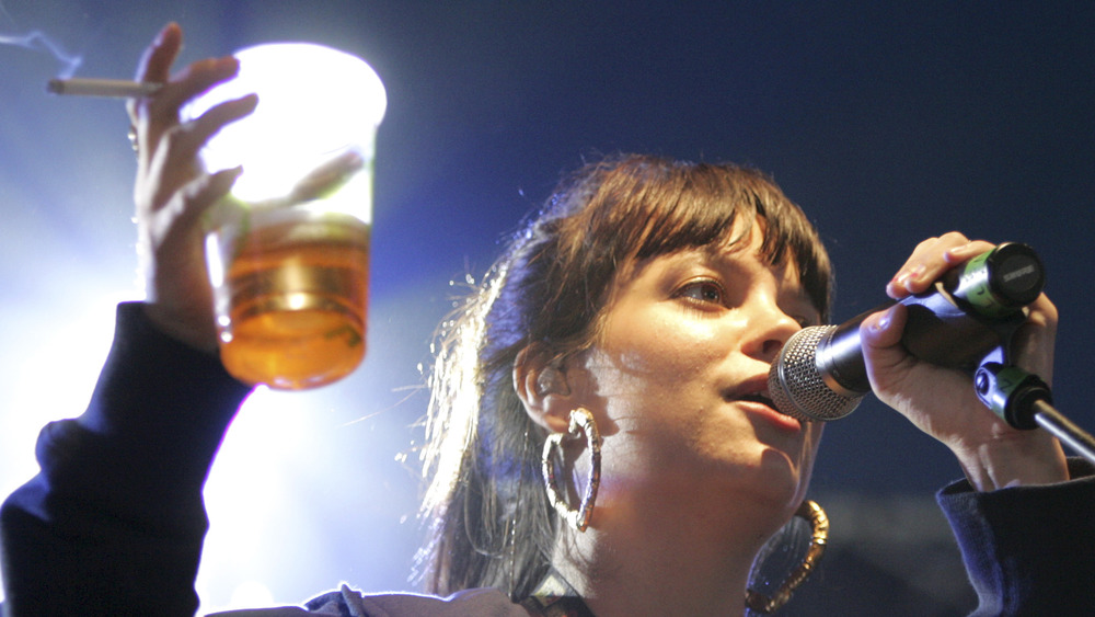 Lily Allen singing with beer and cigarette in hand