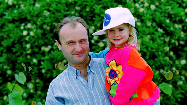 Phil Collins holds young Lily