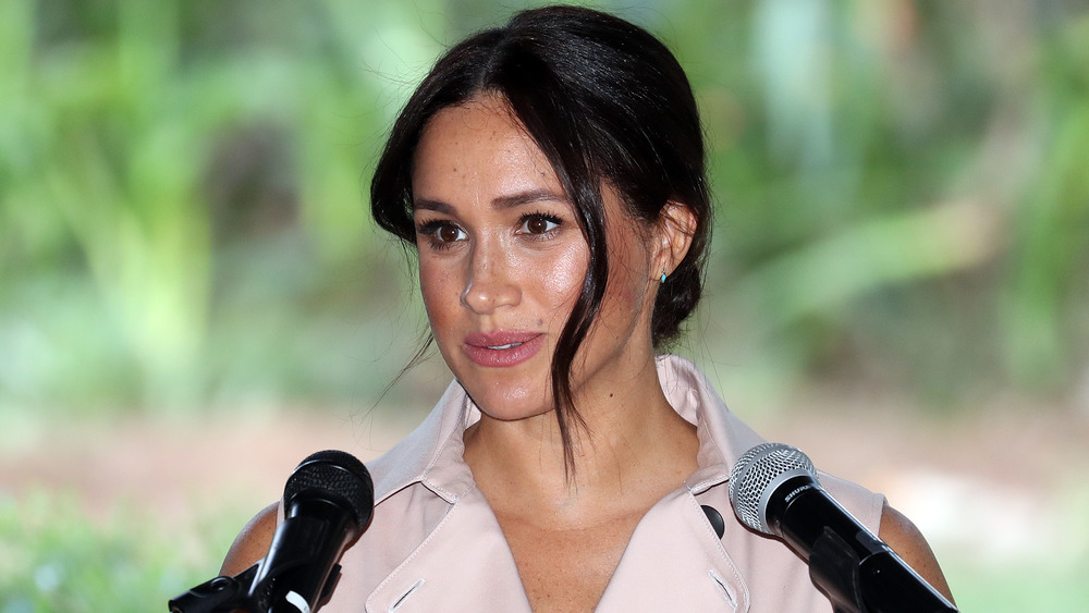 Meghan Markle speaking into two microphones