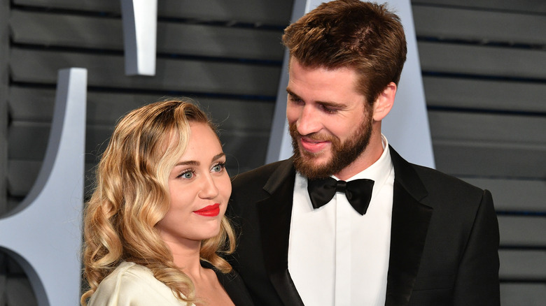 Miley Cyrus and Liam Hemsworth posing on the red carpet