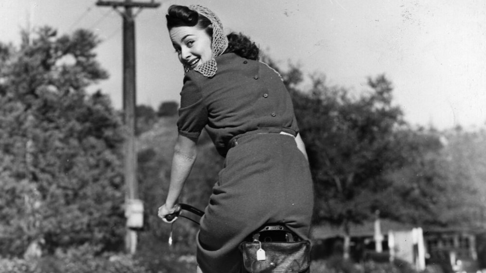 Black-and-white photo of Olivia de Havilland riding a bike in 1938