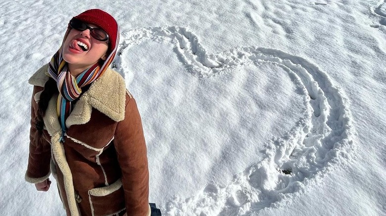 Olivia Rodrigo sticks out her tongue while posing in the snow