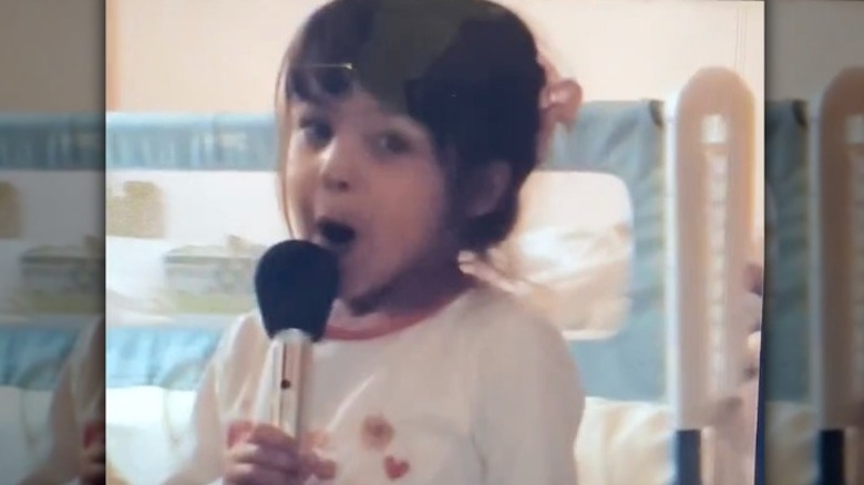 Olivia Rodrigo sings holding microphone as a child