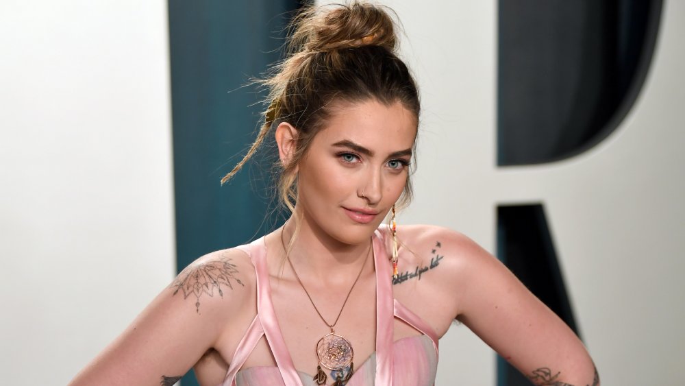 Paris Jackson con tatuajes en los hombros y el pelo recogido en un moño