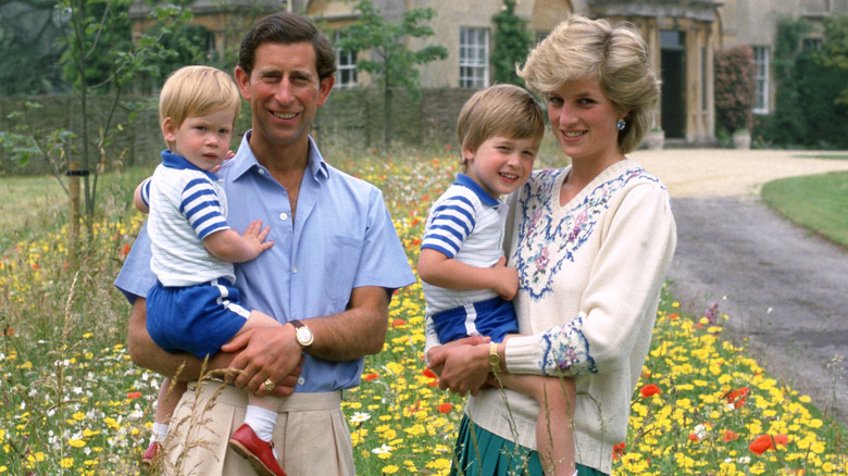 King Charles III holding young Prince Harry and Princess Diana holding young Prince William