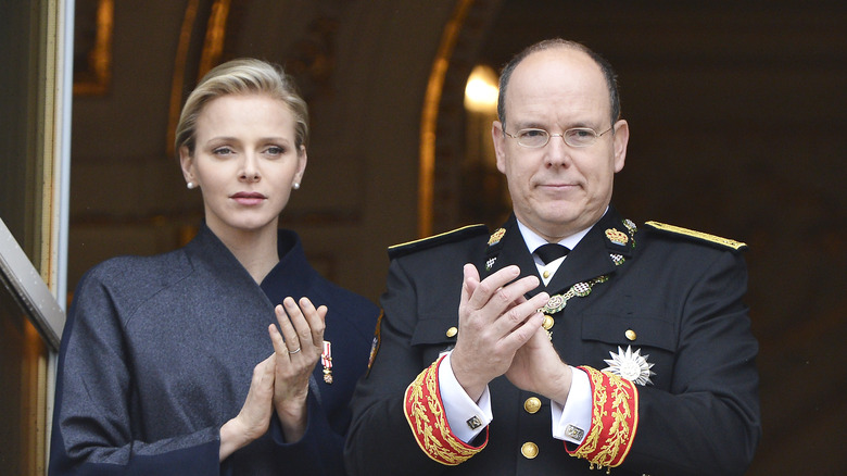 Princess Charlene sad, Prince Albert clapping