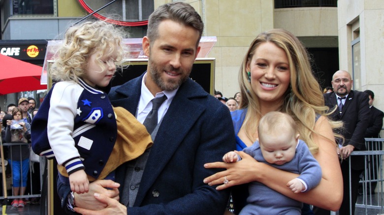 Ryan Reynolds and Blake Lively holding two of their daughters