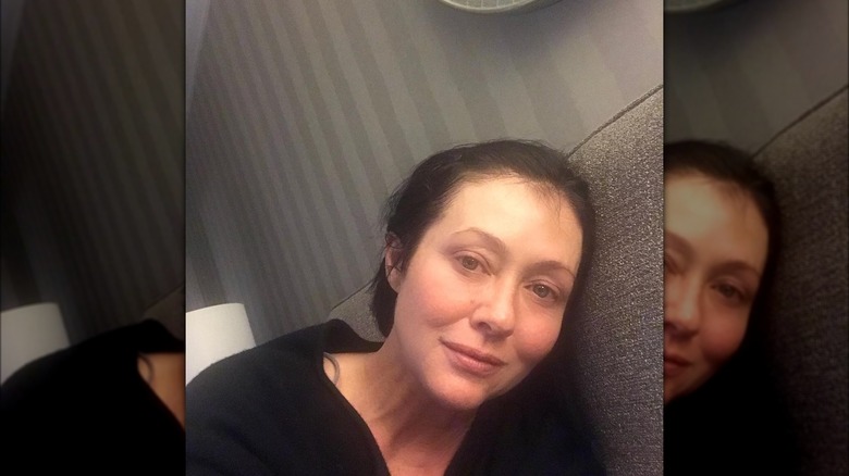 Shannen Doherty with head resting on couch