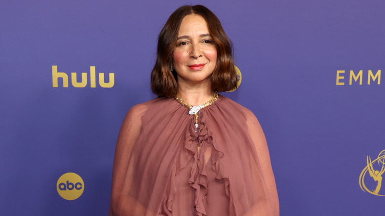 Maya Rudolph wearing a gold snake necklace and dusty rose chiffon dress