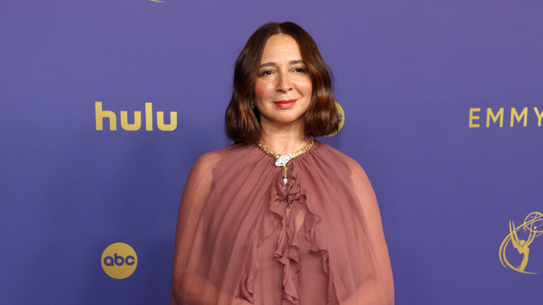 Maya Rudolph standing and smiling for photographers at an event