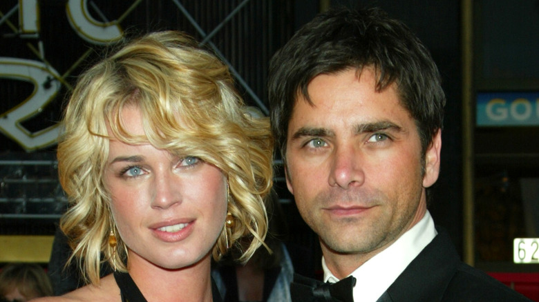 Rebecca Romijn and John Stamos posing