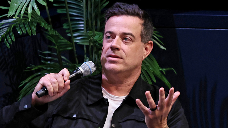 Carson Daly speaking into a microphone on stage