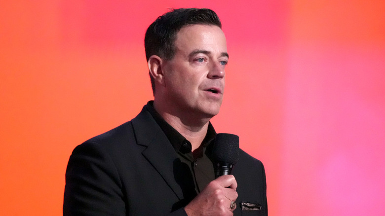 Carson Daly speaking into a microphone on stage