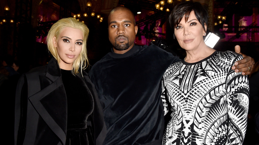 Kim Kardashian, Kanye West, and Kris Jenner posing arm in arm