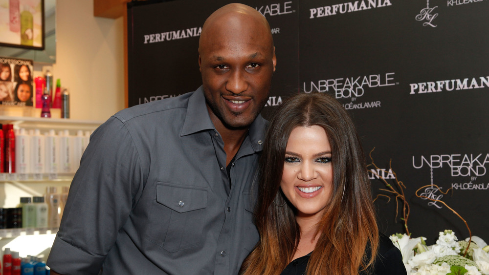 Lamar Odom and Khloe Kardashian smiling while posing arm in arm