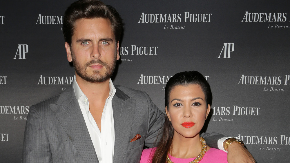 Scott Disick and Kourtney Kardashian posing arm in arm