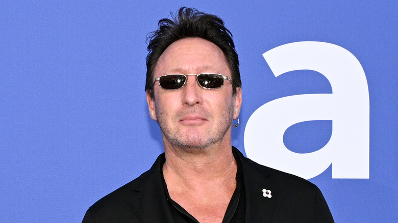 Julian Lennon wearing a black button down shirt and black sunglasses