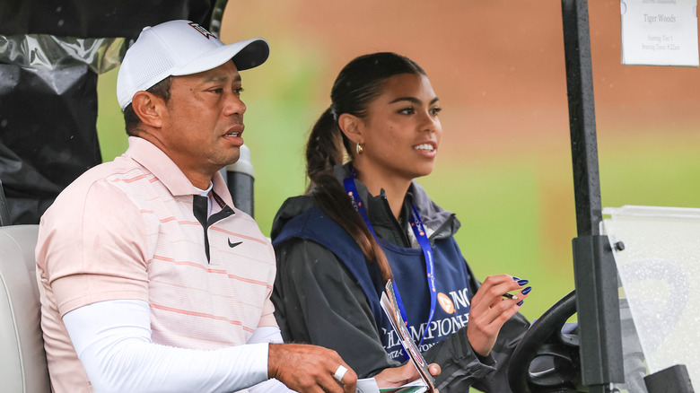 Sam Alexis Woods driving a golf cart with Tiger Woods