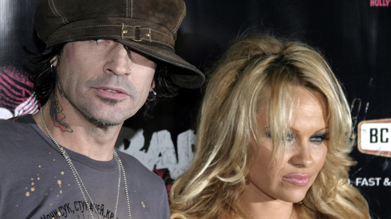 Tommy Lee wearing hat beside Pamela Anderson