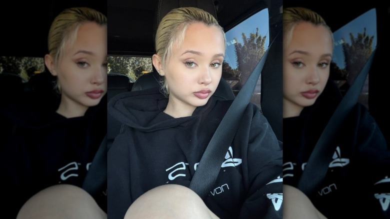 Alabama Barker takes a selfie in the car wearing a black hoodie