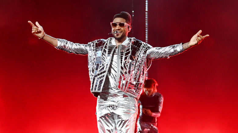 Usher performing in silver outfit