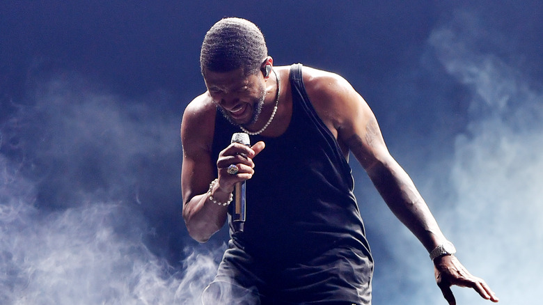 Usher performing in black tank top