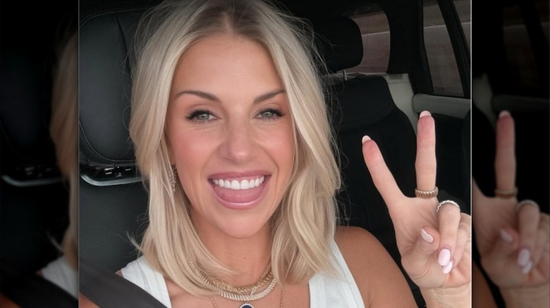 Kelly Stafford gives the peace sign while taking a selfie