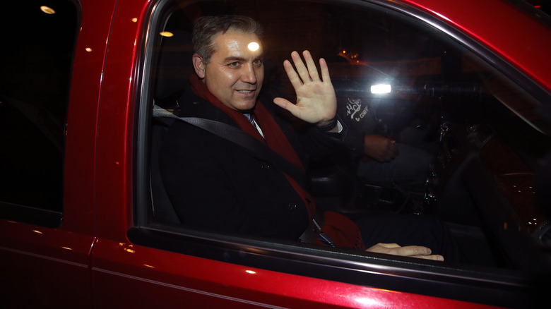 Jim Acosta greets people from inside his car.