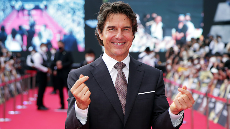 Tom Cruise snapping his fingers on a red carpet